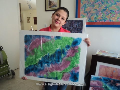 Kimberly Miranda Villalobos, hija de Juan Antonio, posando con una de sus obras.
