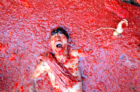 Las calles de una ciudad del este de España se inundaron de pulpa roja cuando miles de personas se arrojaron tomates en la batalla anual llamada la "Tomatina", que se ha convertido en una gran atracción turística.