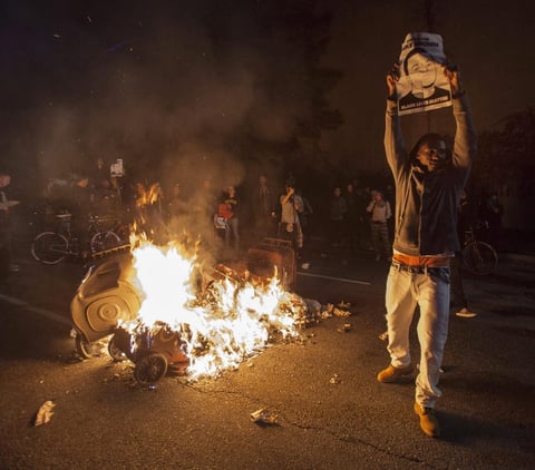 Vehículos y edificios en llamas, comercios saqueados y enfrentamientos entre manifestantes y agentes son las imágenes de la avenida West Florissant de Ferguson y sus alrededores, epicentro de la ola de disturbios raciales que desató el 9 de agosto la muerte de Brown, desarmado y con 18 años, a manos del agente blanco Darren Wilson.