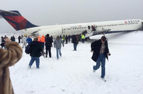 Los pasajeros abandonaron el avión deslizándose por una rampa inflable hacia el pavimento cubierto de nieve.