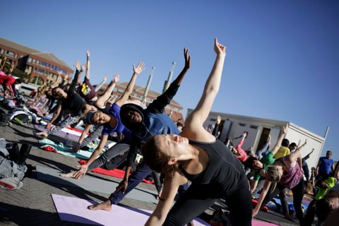 Algunos de los cientos de entusiastas del yoga mantienen sus poses en una sesión especial para el Día de Mandela en Constitution Hill en Johannesburgo , Sudáfrica.