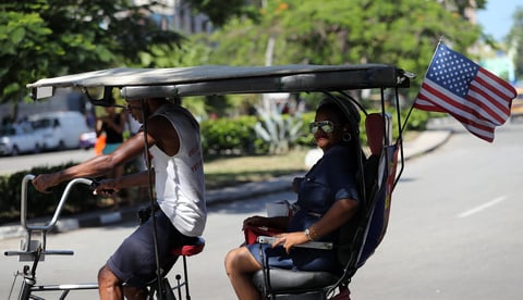 Un bicitaxi con una bandera de Estados Unidos circula en La Habana (Cuba).
