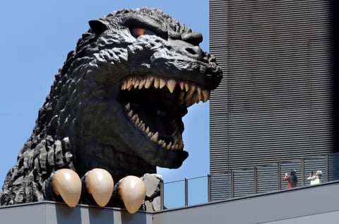 La gente toma fotografías de la cabeza de Godzilla de Toho en Shinjyuku edificio en el distrito de Kabukicho en Tokio Japón.