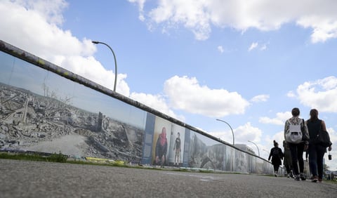 BERLÍN (ALEMANIA).- Varios turistas observan un mural decorado con fotografías de una ciudad destruída de Siria en la galería de arte East Side en Berlín, Alemania. El fotografo Kai Wiedenhöfer presenta sus fotografías tomadas durante la guerra de Siria en la exposición 'War on Wall' (Guerra en la Pared) sobre el antiguo Muro de Berlín. La exposición está disponible hasta el próximo 25 de septiembre. EFE
