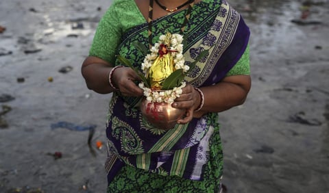 BOMBAY (INDIA).- Una mujer de la comunidad Koli reza con un coco durante las celebraciones del festival Nariyal Purnima en Bombay, India. El festival Nariyal Purnima es el equivalente al Raksha Bandhan para la comunidad Koli de pescadores, una celebración de la unión entre hermanos y hermanas. En el festejo las hermanas atan el llamado "rakhi" alrededor de las muñecas de sus hermanos a cambio de su protección. EFE