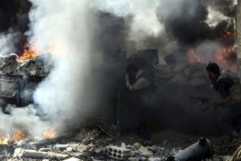 DOUMA (SIRIA).- Combatientes del Ejército del Islam, una de las principales facciones rebeldes de Siria, crean una columna de humo para protegerse de los francotiradores durante los combates en la ciudad de Douma, en las afueras de Damasco, Siria. EFE