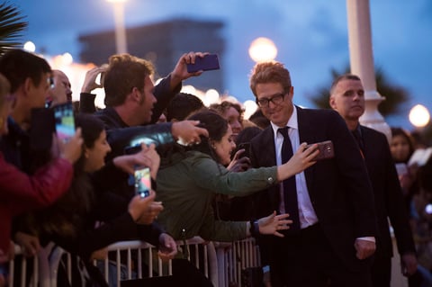 El actor Hugh Grant posó junto a una seguidora en la alfombra roja del festival donde presentó el filme Florence Foster Jenkins.