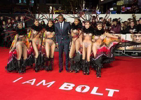 El hombre más rápido del mundo posó junto a unas bailarinas en la premier.