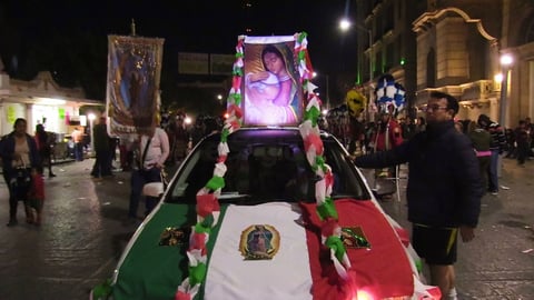 Carros alegóricos adornados con globos, banderas mexicanas y  con imágenes de la virgen sobresaliendo en ellos.