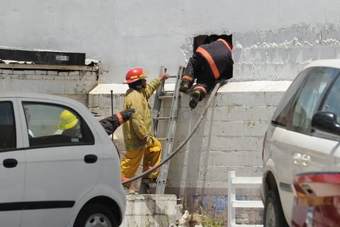 Los bomberos tuvieron que hacer boquetes para poder controlar el incendio.