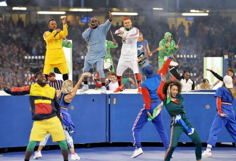 150 bailarines profesionales, 120 militares, encargados de desplegar la alfombra gigante sobre el césped, 172 del personal de producción, cinco músicos y los tres cantantes de Black Eyed Peas.