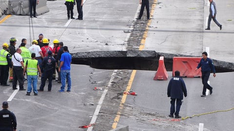 Personal de Protección Civil de Morelos realiza labores de extracción del vehículo que cayó a un socavón en el kilómetro 93 del Paso Express, en la autopista Cuernavaca-México.