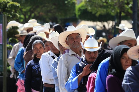 En la imagen resaltan algunos adultos mayores que hacen fila en el banco para extraer los apoyos gubernamentales.