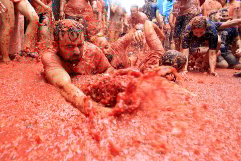 Los asistentes se arrojan toneladas de tomates maduros hasta terminar bañados en pulpa roja.