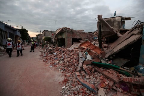 Miembros del Equipo de la Cruz Roja caminan por las calles afectadas por el temblor.