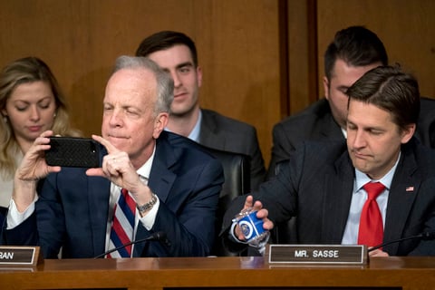 El senador Jerry Moran toma una fotografía con su celular mientras el Zuckerberg está testificando.