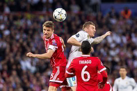 Thomas Muller gana una pelota al también alemán Toni Kroos.