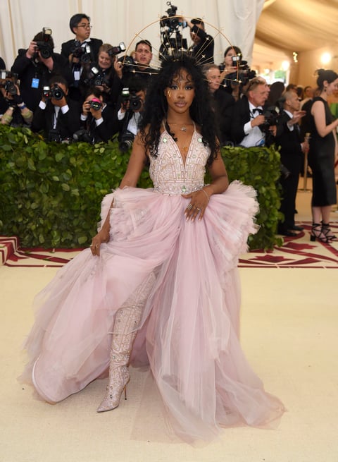 La cantante de R&S, SZA luce un vestido y botas rosa pálido con pedrería y volantes traslúcidos.