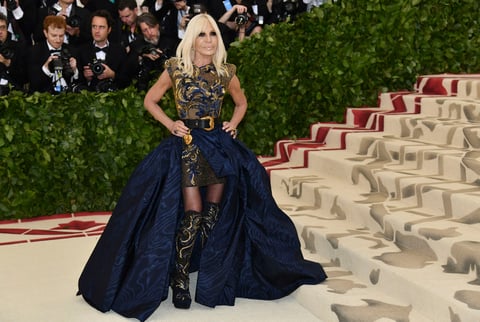 Donatella Versace con botas altas y una vestimenta adornada de lentejuelas.