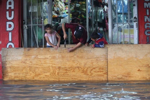 Locatarios comerciales buscaron evitar que el agua entrara a sus negocios.
