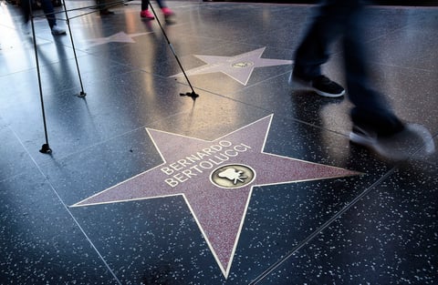 En 1987 estrenó la película que le granjeó un mayor reconocimiento, El último emperador, con la que ganó cuatro Globos de Oro y nueve premios Oscar, entre ellos los de Mejor Película, Mejor Director y Mejor Guión, y que recupera la figura de Puyi, el emperador de China derrocado por la revolución de 1911.