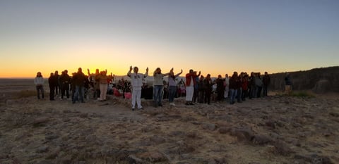 Desde el primer escalón se escuchan los sonidos del tambor, las plegarias y el ritmo de hombres, mujeres y niños que danzan alrededor de ofrendas.