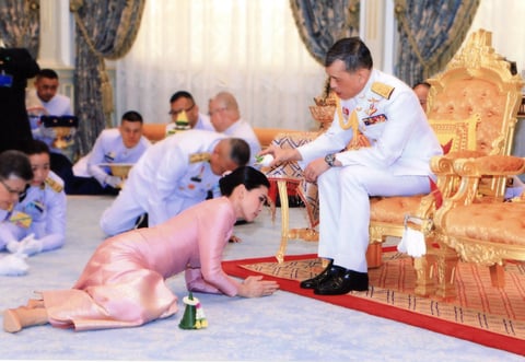 Con un vestido rosa, Suthida y otros asistentes se postraron en un momento de la ceremonia ante el soberano.