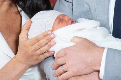 El pequeño lució envuelto en una manta blanca y un gorro del mismo color.