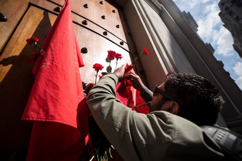 Un hombre coloca flores en la puerta de Morandé 80 del Palacio de La Moneda, por la que entraba el expresidente de Chile Salvador Allende.