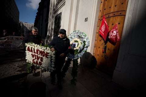 Un par de hombres portan este miércoles una corona floral durante uno de los actos en memoria del expresidente de Chile Salvador Allende, en conmemoración por el 46º aniversario del golpe de Estado de Augusto Pinochet, con el que se dio inicio a la dictadura militar del país austral entre 1973 y 1990.