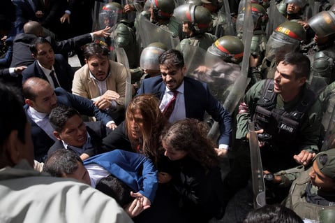 Diputados opositores forcejean con la policía al ver impedida su entrada a la sede de la Asamblea Nacional este domingo, en Caracas (Venezuela). El líder opositor venezolano Juan Guaidó denunció que el país vivió este domingo 'el asesinato de la República' al elegir el chavismo a un nuevo presidente de la Asamblea Nacional (AN, Parlamento) en una sesión a la que le impidieron entrar, así como a un grupo de diputados opositores.