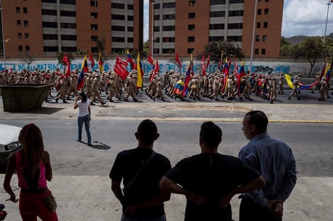 Varias personas observan el lunes 12 de febrero una manifestación de milicianos, en Caracas.