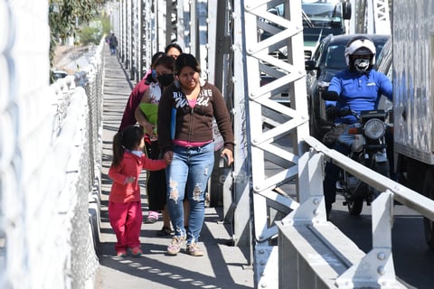 Pasajeros que tuvieron que descender de los autobuses que retornaron, caminaron por las laterales del Puente Plateado.