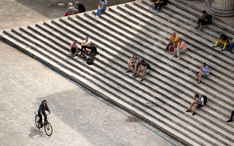 La gente disfruta del sol en las escaleras del palacio de la Colección de Antigüedades en la Koenigsplatz 