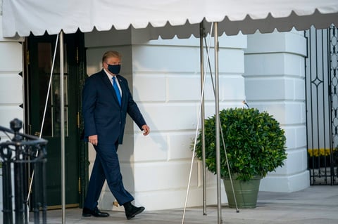 Trump salió de la Casa Blanca vestido de traje, en aparente buen estado, con una mascarilla en la cara, saludando a las cámaras y levantando el pulgar.