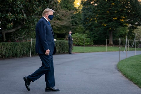 Trump salió de la Casa Blanca vestido de traje, en aparente buen estado, con una mascarilla en la cara, saludando a las cámaras y levantando el pulgar.