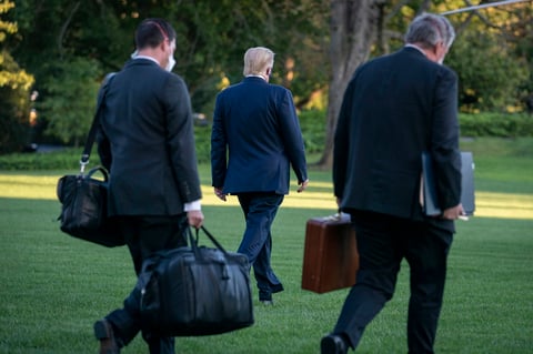 Trump salió de la Casa Blanca vestido de traje, en aparente buen estado, con una mascarilla en la cara, saludando a las cámaras y levantando el pulgar.