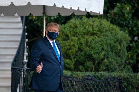 Trump salió de la Casa Blanca vestido de traje, en aparente buen estado, con una mascarilla en la cara, saludando a las cámaras y levantando el pulgar.