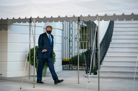 Trump salió de la Casa Blanca vestido de traje, en aparente buen estado, con una mascarilla en la cara, saludando a las cámaras y levantando el pulgar.