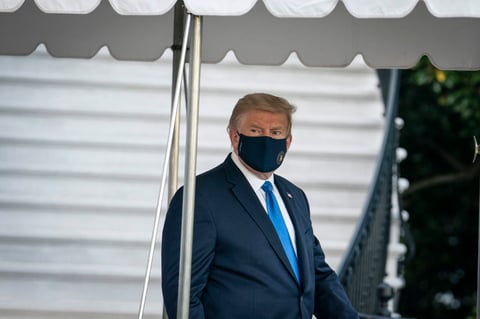 Trump salió de la Casa Blanca vestido de traje, en aparente buen estado, con una mascarilla en la cara, saludando a las cámaras y levantando el pulgar.
