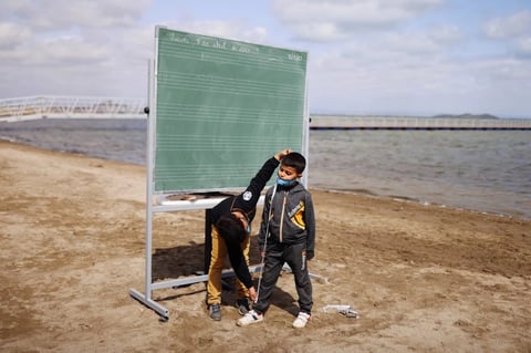 Niños en España toman clases presenciales frente al mar