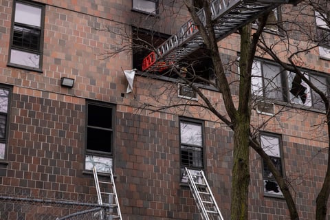 Ladders are seen erected beside the apartment building in the Bronx after a fire occurred on Sunday, Jan. 9, 2022, in New York. (AP Photo/Yuki Iwamura)