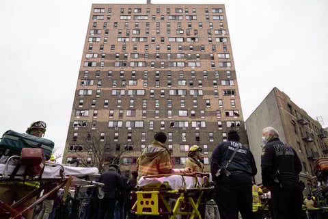 Emergency personnel work at the scene of a fatal fire at an apartment building in the Bronx on Sunday, Jan. 9, 2022, in New York. The majority of victims were suffering from severe smoke inhalation, FDNY Commissioner Daniel Nigro said. (AP Photo/Yuki Iwamura)