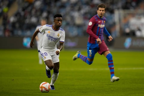 Real Madrid's Vinicius Junior in action in front of Real Madrid's Eder Militao during the Spanish Super Cup semi final soccer match between Barcelona and Real Madrid at King Fahd stadium in Riyadh, Saudi Arabia, Wednesday, Jan. 12, 2022. (AP Photo/Hassan Ammar)