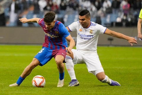 Barcelona's Abdessamad, left, and Real Madrid's Casemiro fight for the ball during the Spanish Super Cup semi final soccer match between Barcelona and Real Madrid at King Fahd stadium in Riyadh, Saudi Arabia, Thursday, Jan. 13, 2022. (AP Photo/Hassan Ammar)