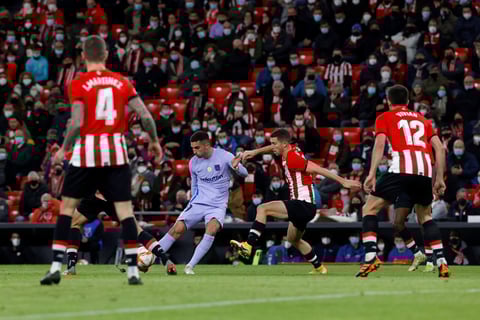 BILBAO, 20/01/2022.- El delantero del FC Barcelona, Ferrán Torres (3d), se dispone a golpear el balón ante el defensa del Athletic Club, Oscar de Marcos, para conseguir el primer gol del equipo barcelonista durante el encuentro correspondiente a los octavos de final de la Copa del Rey que disputan hoy jueves en el estadio de San Mamés, en Bilbao. EFE / Miguel Toña.