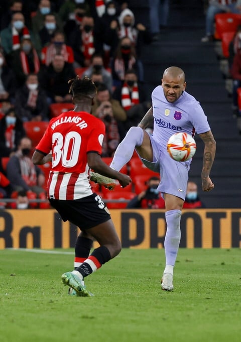 BILBAO, 20/01/2022.- El defensa brasileño del FC Barcelona, Dani Alves (d), controla el balón ante el delantero del Athletic Club, Nico Williams, durante el encuentro correspondiente a los octavos de final de la Copa del Rey que disputan hoy jueves en el estadio de San Mamés, en Bilbao. EFE / Miguel Toña.