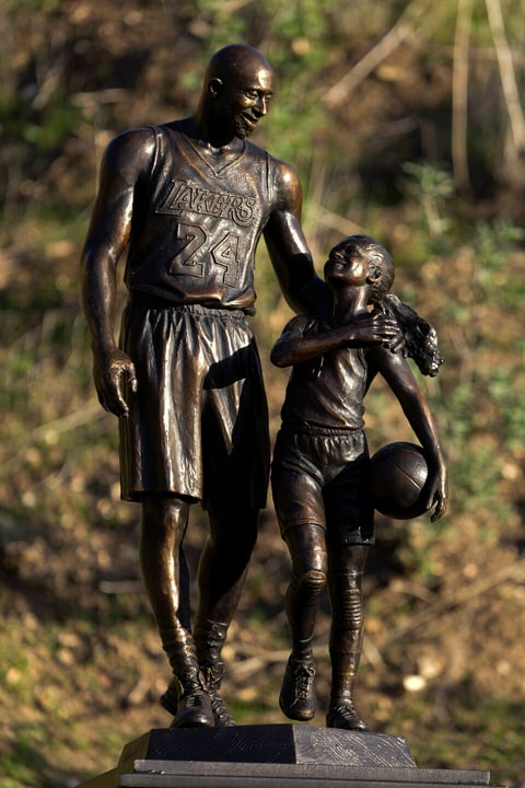 A bronze sculpture honoring former Los Angeles Lakers NBA basketball player Kobe Bryant, his daughter Gianna Bryant, and the names of those who died, is displayed at the site of a 2020 helicopter crash in Calabasas, Calif, on Wednesday, Jan. 26, 2022. (AP Photo/Ringo H.W. Chiu)