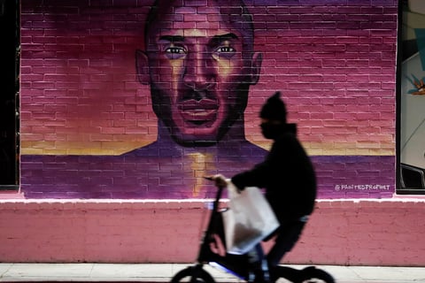 Los Angeles (United States), 27/01/2022.- A person rides past a mural of former Los Angeles Lakers NBA basketball player Kobe Bryant in Los Angeles, California, USA, 26 January 2022. Bryant and his daughter Giana, along with seven other people, died in a helicopter crash two years ago. (Baloncesto, Estados Unidos) EFE/EPA/CAROLINE BREHMAN