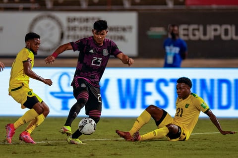Jamaica's Javain Brown, right, watches Mexico's Jesus Gallardo dribbling during a qualifying soccer match for the FIFA World Cup Qatar 2022 in Kingston, Jamaica, Thursday, Jan. 27, 2022. (AP Photo/Ramon Espinosa)